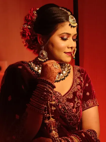 A beautiful portrait of the bride. Her makeup features a soft glam eye and a bold red lip, perfectly suiting her velvet blouse and traditional jewelry.