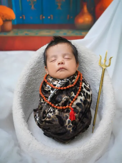 A vertical composition of the 'Little Shiva' theme, highlighting the baby's peaceful sleep amidst the divine setup.