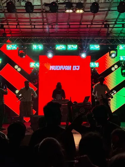 A clear shot of the stage setup, showing me at the DJ console with my Chenda players on either side, ready to perform.