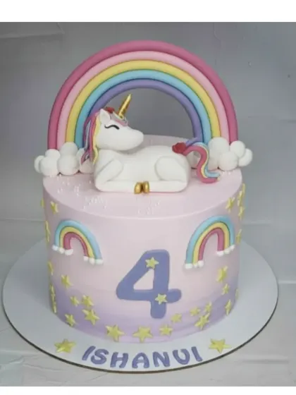 A magical unicorn cake for a 4th birthday. This basic vanilla cake is covered in light whipped cream and adorned with a detailed, handmade fondant unicorn and rainbow.