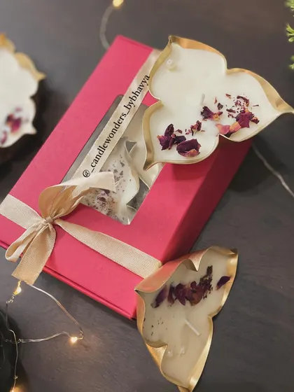 A simple and elegant Diwali gift box containing two leaf-shaped urli candles. It's a budget-friendly yet beautiful option.
