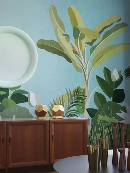 This design shows how a stylized, graphic tropical wallpaper can complement mid-century modern furniture. The bold green leaves against a solid blue background create a chic and artistic statement.