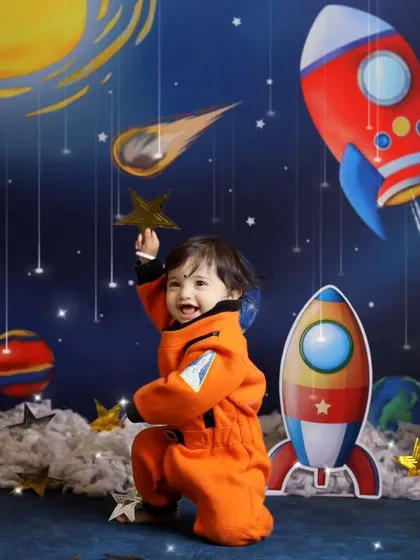 Reaching for the stars. This pose captures the playful and adventurous spirit of our space explorer theme, perfect for curious toddlers.