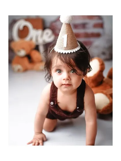 The birthday boy crawling towards the camera during his bear-themed first birthday shoot.