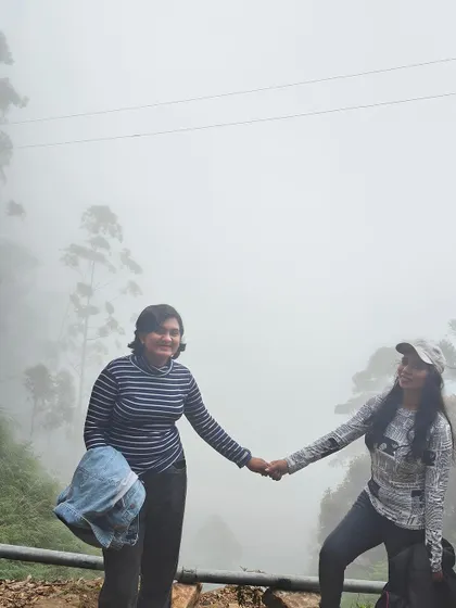Two friends holding hands in the misty Kodaikanal hills.