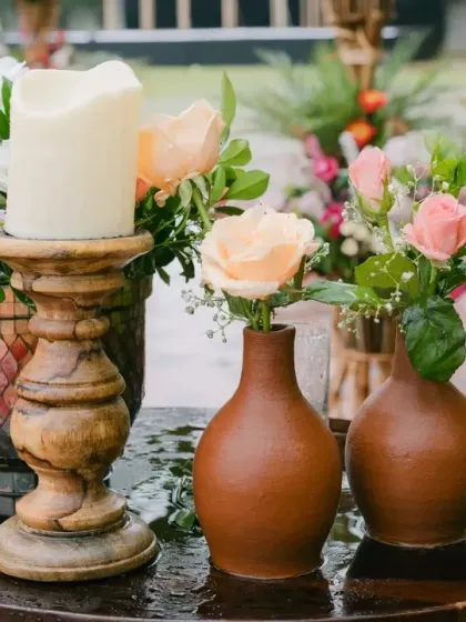 A close-up of the charming details from a rainy wedding day. The combination of pastel florals in rustic, handmade pots creates a look that is both simple and incredibly beautiful.