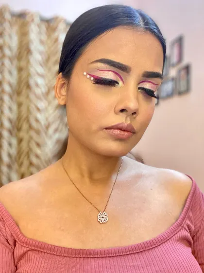 A close-up of a graphic eyeliner look. I used a bold pink liner and delicate pearl accents to create a modern, artistic, and dreamy eye makeup style.