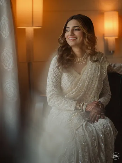 A beautiful portrait of the bride by a window, with soft, natural light illuminating her happy face.