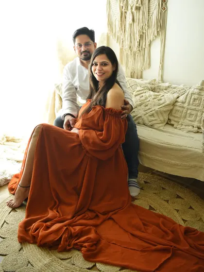A full-length view showing the beautiful flow of the rust-colored gown. This setup is perfect for creating a relaxed, earthy, and bohemian vibe for your maternity pictures.