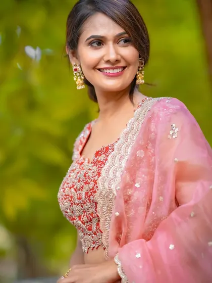 A beautiful smile from Kavya Gowda. This close-up shows the fresh and radiant makeup, with a pop of color on the lips that brightens her entire face.