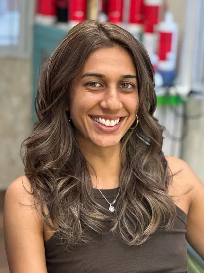 A happy client showing off her new, confidence-boosting hair color.