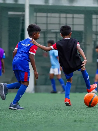 A player challenges for the ball during a practice game. Competitive drills are a core part of our methodology to prepare players for match day.