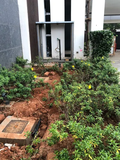 **Before:** This small bed next to the house was a challenging space, with exposed pipes and uneven ground. The client wanted something beautiful but easy to care for.