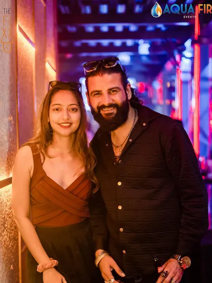 A guest posing with a friend against the cool interior of the club.