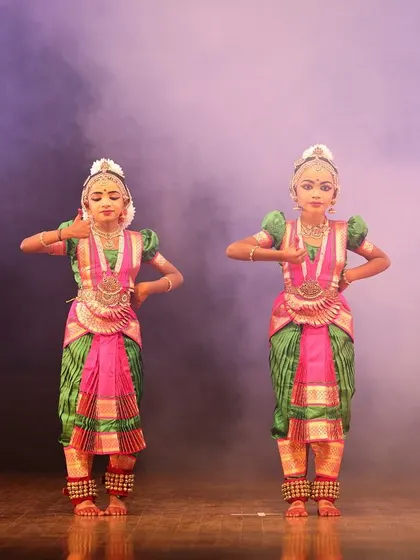 A quartet of young dancers in perfect unison, their identical postures and expressions reflecting their dedicated practice and discipline.