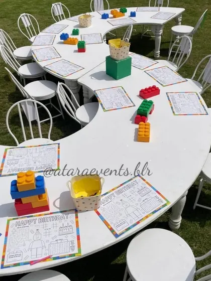 A unique serpentine table setup for the kids' activity area, with LEGO blocks as centerpieces and coloring sheets at each seat.