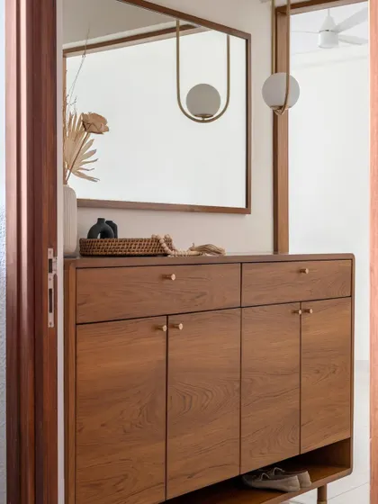This custom shoe cabinet features our signature style of clean lines, warm wood, and brass hardware, with a convenient open shelf for everyday footwear.