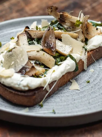For our vegetarian friends, the wild mushroom toast. Sautéed mushrooms and parmesan shavings over a creamy spread on our signature sourdough.