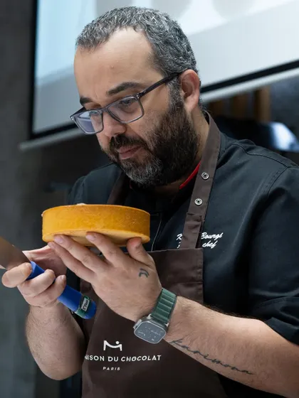 Chef Karim Bourgi inspecting a freshly baked cake layer before assembly.
