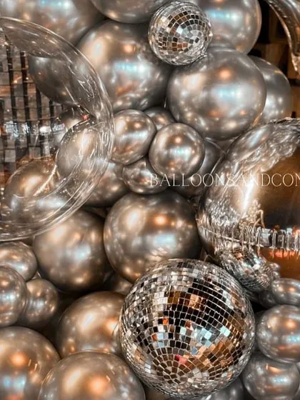 A macro shot of the details. You can see the reflection in the chrome balloons and the sparkle of the disco balls, all key elements of our glam party style.