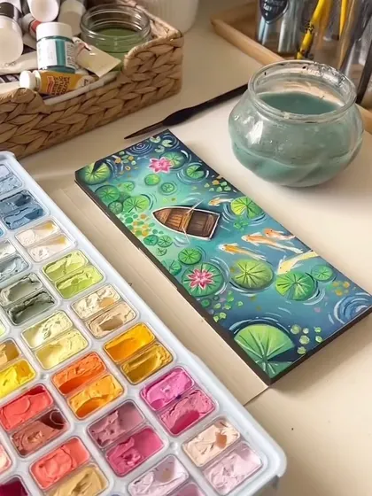 A beautiful gouache painting of a lily pond, complete with a small wooden boat. This piece was inspired by peaceful, dreamy landscapes and is filled with details like koi fish, lily pads, and pink water lilies.