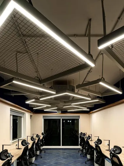 This view shows how the geometric light fixtures create a cohesive and dynamic ceiling-scape. The design ensures that every workstation receives consistent, high-quality illumination, promoting focus and well-being.