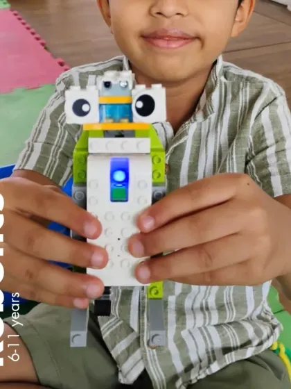 "Say hello to my robot!" This student proudly displays his creation, built for our 6-11 years robotics program.