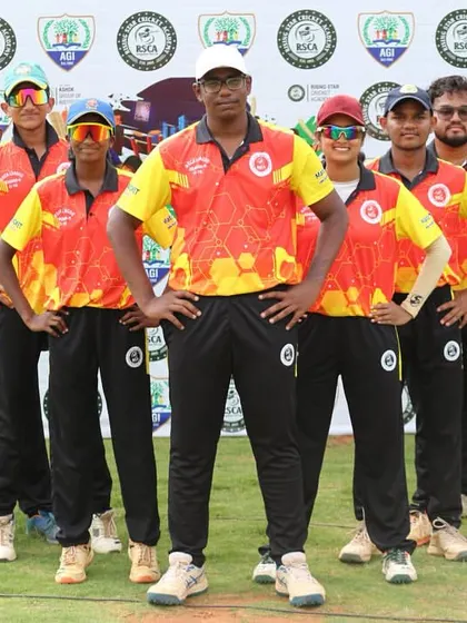 A team in red and yellow jerseys stands for a powerful team photo before their league match.