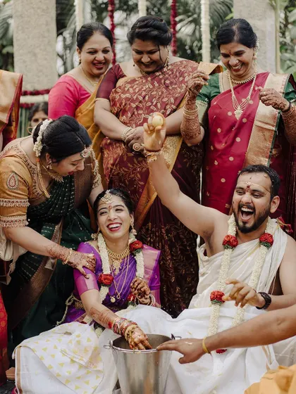 The ring-finding game is always a highlight, filled with laughter and friendly competition. This image captures the groom's triumphant joy, a fun, candid moment that shows the couple's playful dynamic.