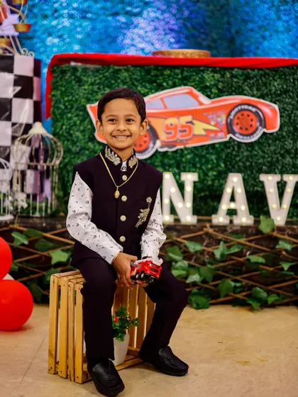The birthday boy posing with his favorite toy car in front of his party's themed backdrop. I always capture the special details you've planned.