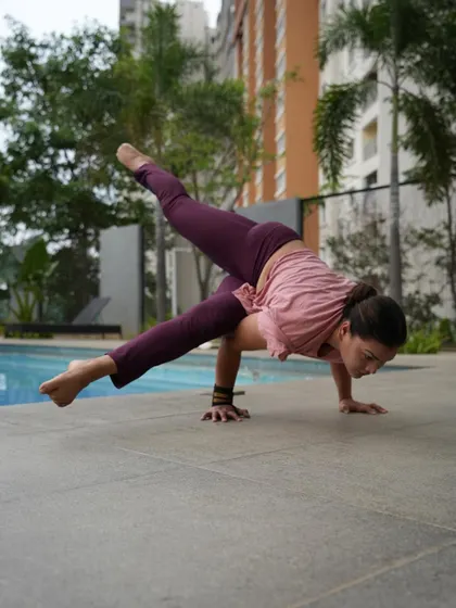 Practicing Eka Pada Koundinyasana II by the poolside. This arm balance requires a combination of twisting, hip opening, and upper body strength.