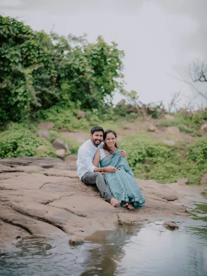 A couple sitting together by the water, enjoying a peaceful moment during their pre-wedding session.