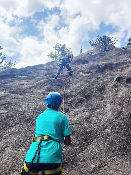 A climber is safely belayed from below during a top-rope climb.