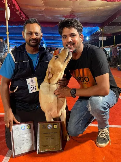 A happy moment between a handler and his dog after winning an award.