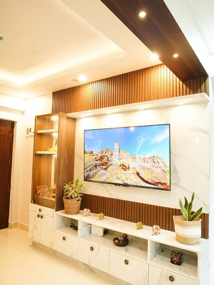 A full view of the entertainment wall, showing the beautiful contrast between the white marble, dark wood, and warm lighting. This unit provides ample storage and display space.