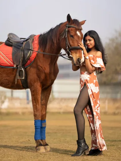 A stylish pose with the model standing next to the horse, showcasing both the fashion and the majestic animal.