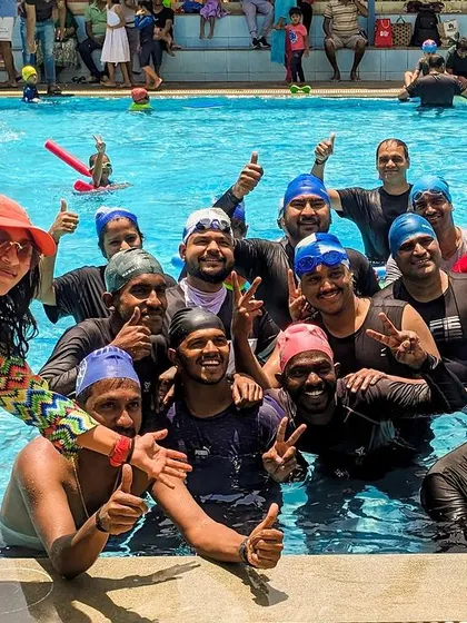 It's not just for kids. This happy group of adult swimmers celebrates the start of a fun-filled summer camp session, proving that learning and fun have no age limit.