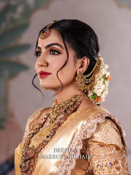 A side profile of the bride, highlighting the elegant hair bun adorned with fresh flowers and the beautiful earring details.