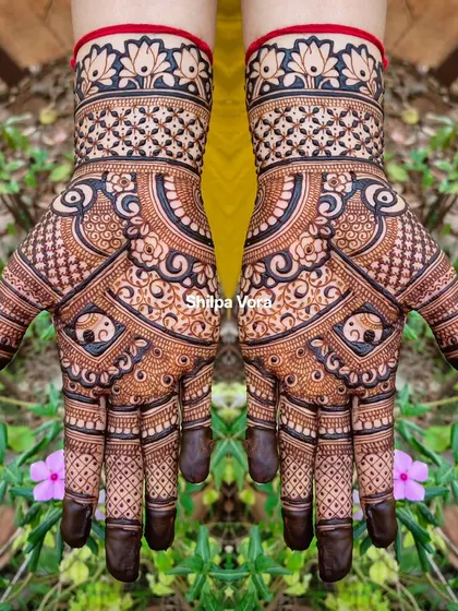A symmetrical design featuring elephant motifs inside a circular pattern, set against a natural background.
