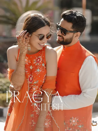 A stylish portrait of the couple in color-coordinated orange outfits for their Mehndi.