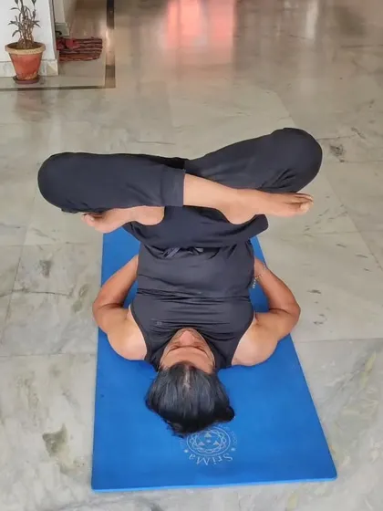 A student practices Urdhva Padmasana in Sarvangasana (Upward Lotus in Shoulder Stand). I guide students through advanced inversions, focusing on safety and proper alignment.