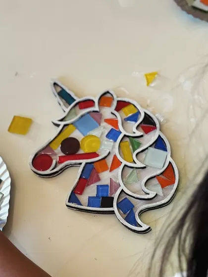 A close-up of a finished unicorn mosaic. The mix of colors and shapes creates a beautiful and unique piece of art.