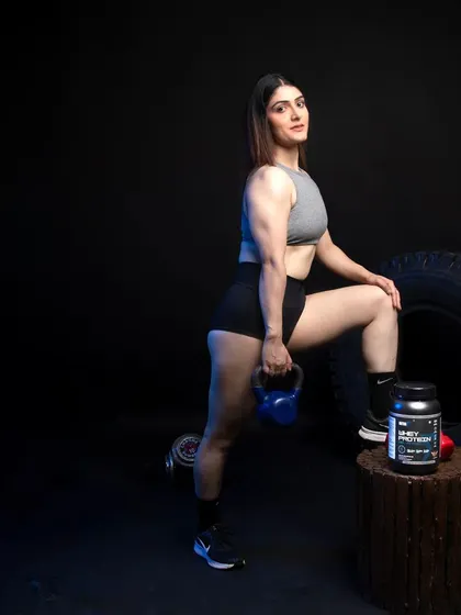 A female model in a lunge position with a kettlebell, demonstrating a common exercise. The product is placed nearby to suggest it's part of her fitness regimen.