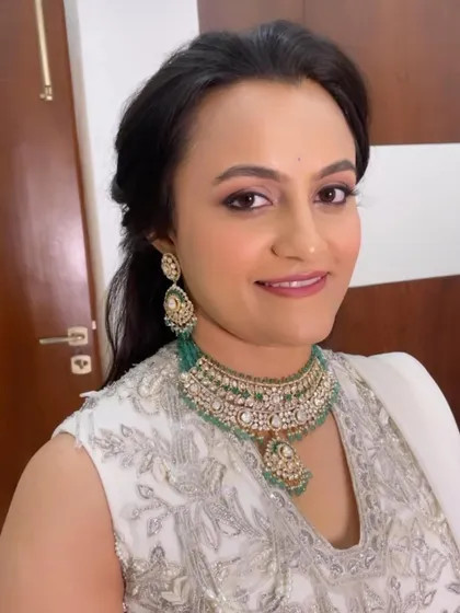 A close-up portrait of the final sangeet look. The eyes are softly defined with a hint of shimmer, and the skin looks flawless and radiant.