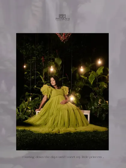 Another perspective from our creative night-time maternity shoot. This image captures the mother-to-be in her flowing gown, surrounded by glowing lights and lush greenery, creating a sense of enchantment and anticipation.