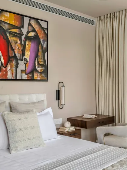 In the Parishram residence, we designed this bedroom with a focus on tactile materials and art. A floating wooden desk serves as a compact workspace, while the abstract painting adds a layer of intellectual curiosity.