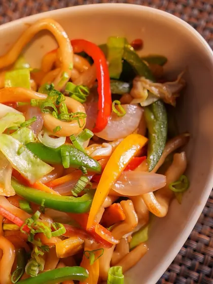 A close-up of our Yakisoba, a classic Japanese stir-fried noodle dish. The noodles are tossed with crisp vegetables and a savory sauce, creating a symphony of flavors.
