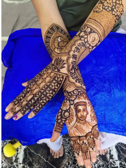 A look at the full design, showing how the portrait on the palm connects with the peacock and floral motifs wrapping around the arm.