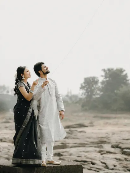 Looking up at the sky together, waiting for their kite to fly. A moment of shared hope and anticipation.
