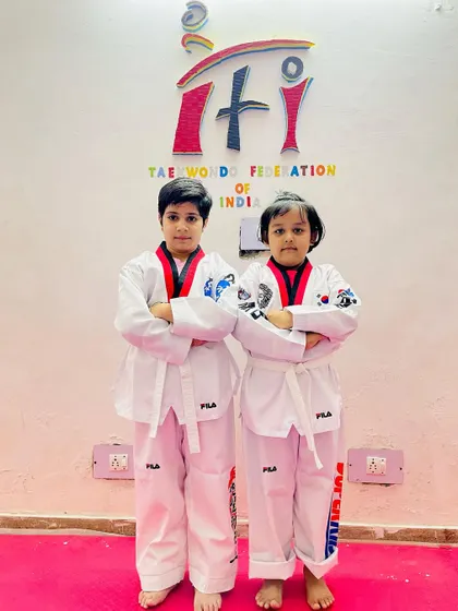 Two of our academy's cute and dedicated students. They are learning to be strong and disciplined, with their arms crossed in a confident pose.